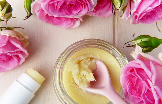 pink flowers with bowl and tube of lotion